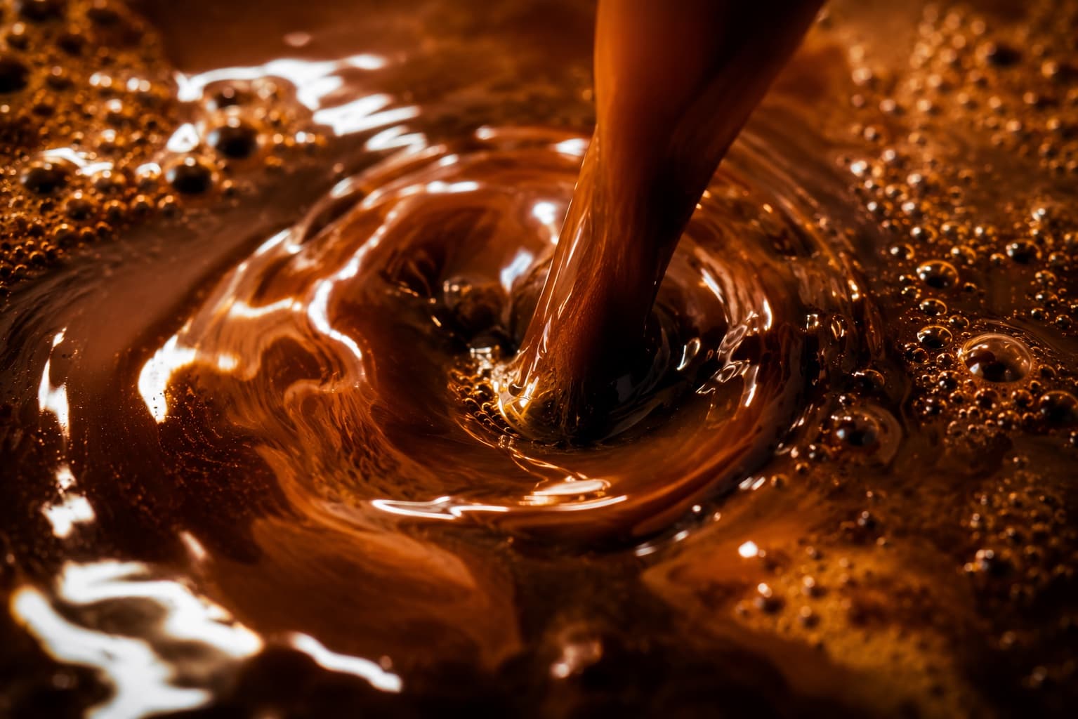 Extreme macro of dark espresso crema swirling in glossy amber and black.